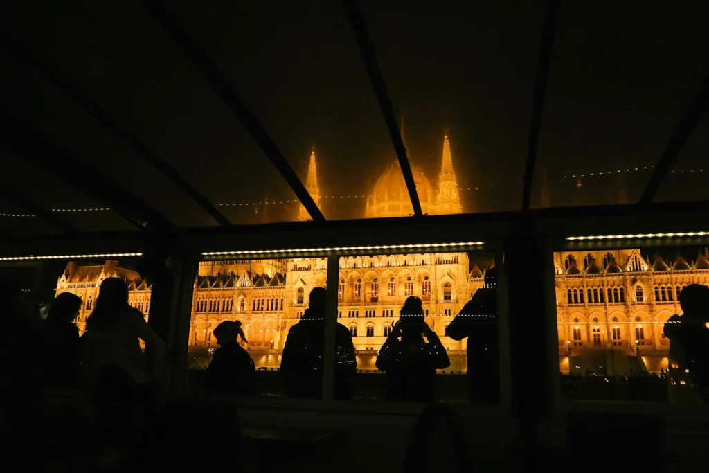 Night view of the Hungarian Parliament through the windows of a boat cabin on the Danube in Budapest.