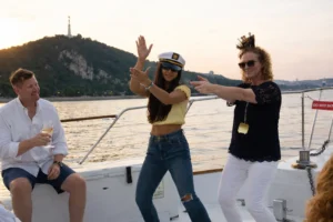 Friends enjoying a relaxed moment on a private boat cruise in Budapest, Danube views with Gellért Hill in the background